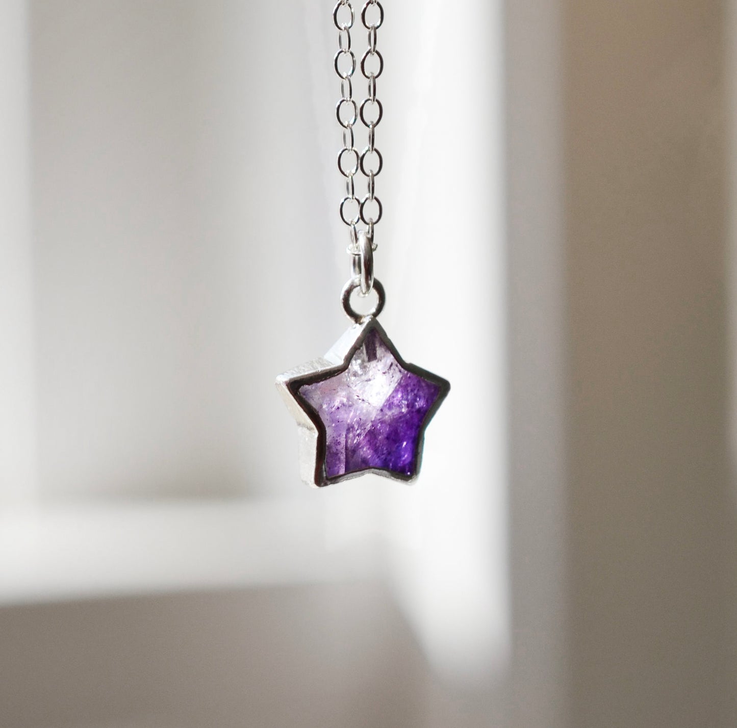 Handmade natural purple amethyst star pendant set on a sterling silver chain.