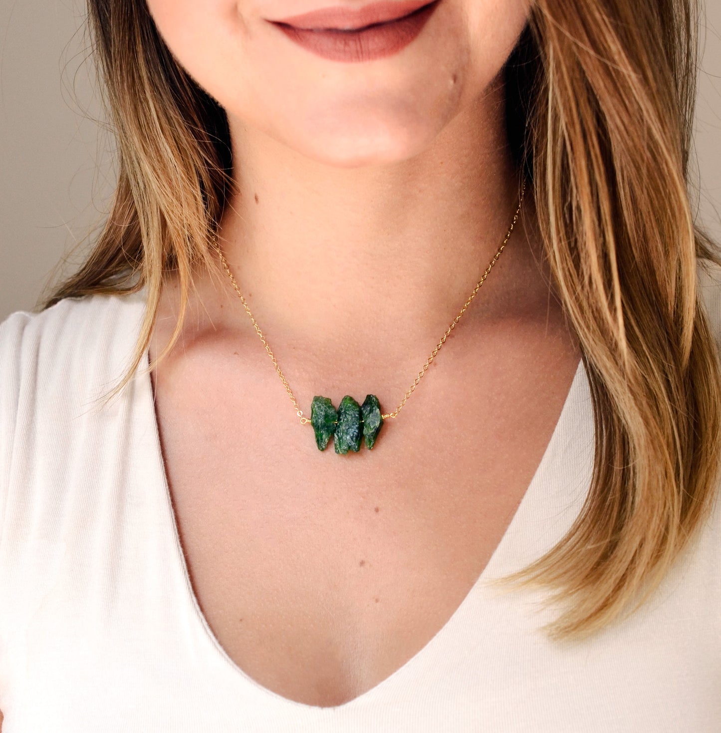 Natural green Chrome Diopside raw crystals set onto a gold filled chain. Modeled image.