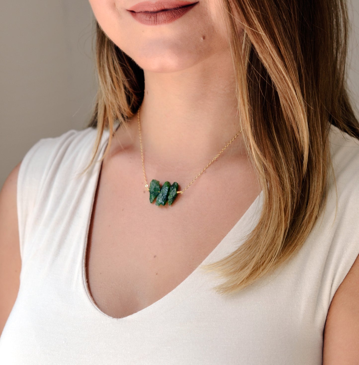 Natural green Chrome Diopside raw crystals set onto a gold filled chain. Modeled image.