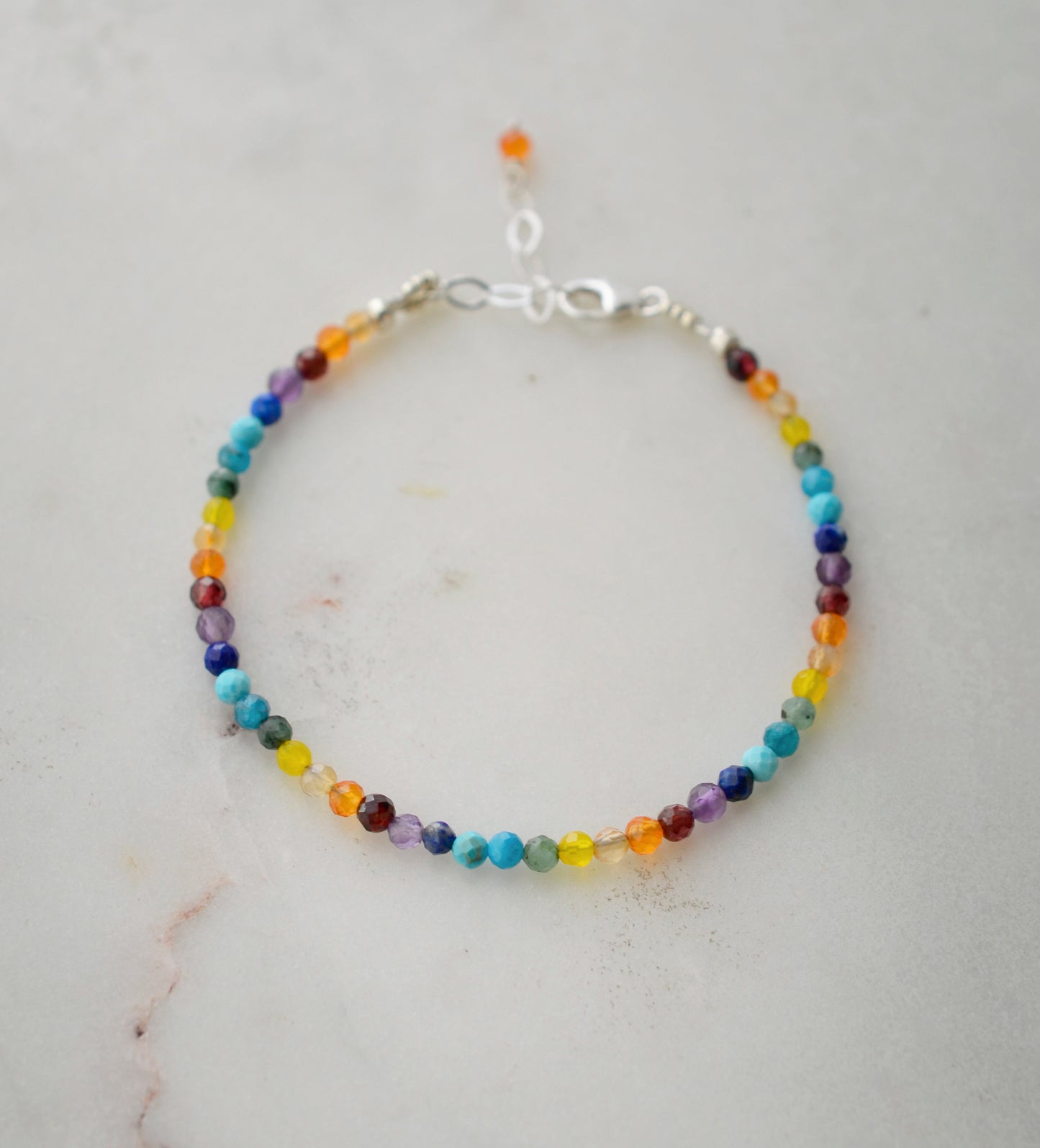 Tiny gemstone beaded bracelet in rainbow colors. Colors include: blue, green, yellow, red, orange, and purple.