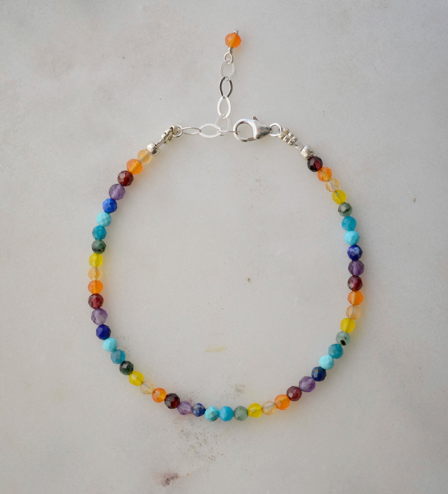 Tiny gemstone beaded bracelet in rainbow colors. Colors include: blue, green, yellow, red, orange, and purple.