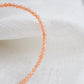 Genuine orange Sunstone beaded bracelet. The stones are round and faceted. Close up image.