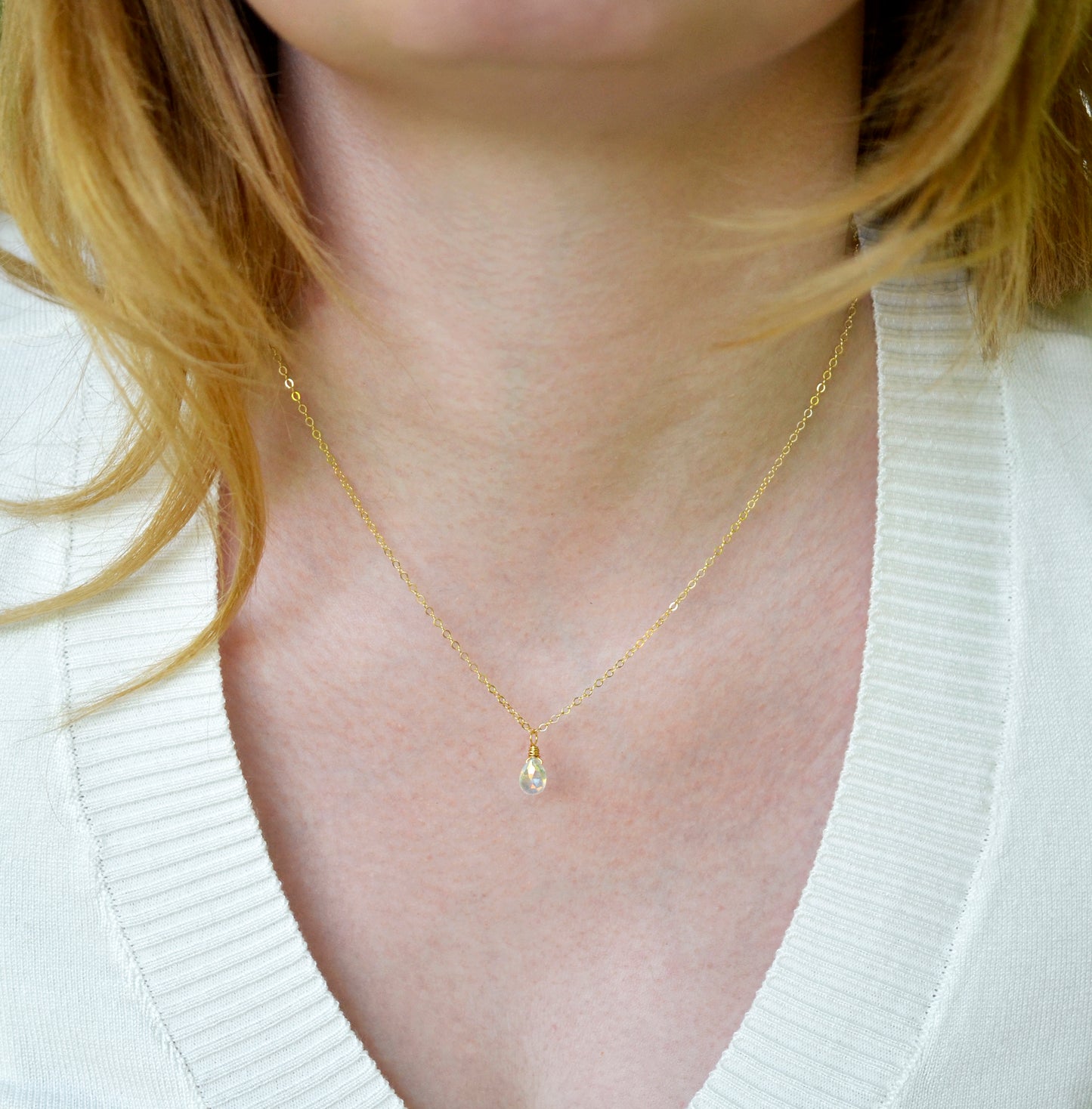 Rainbow Quartz teardrop crystal on a gold filled chain. The stone flashes a shimmering array of rainbow colors. Modeled image.