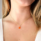 Natural orange Carnelian teardrop gemstone set onto a 14k gold filled chain. Modeled image.