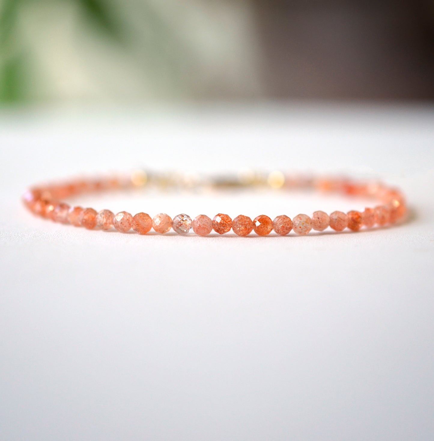 Dainty Sunstone beaded bracelet with orange to clear glittering gemstones. Clasp is sterling silver or gold filled.
