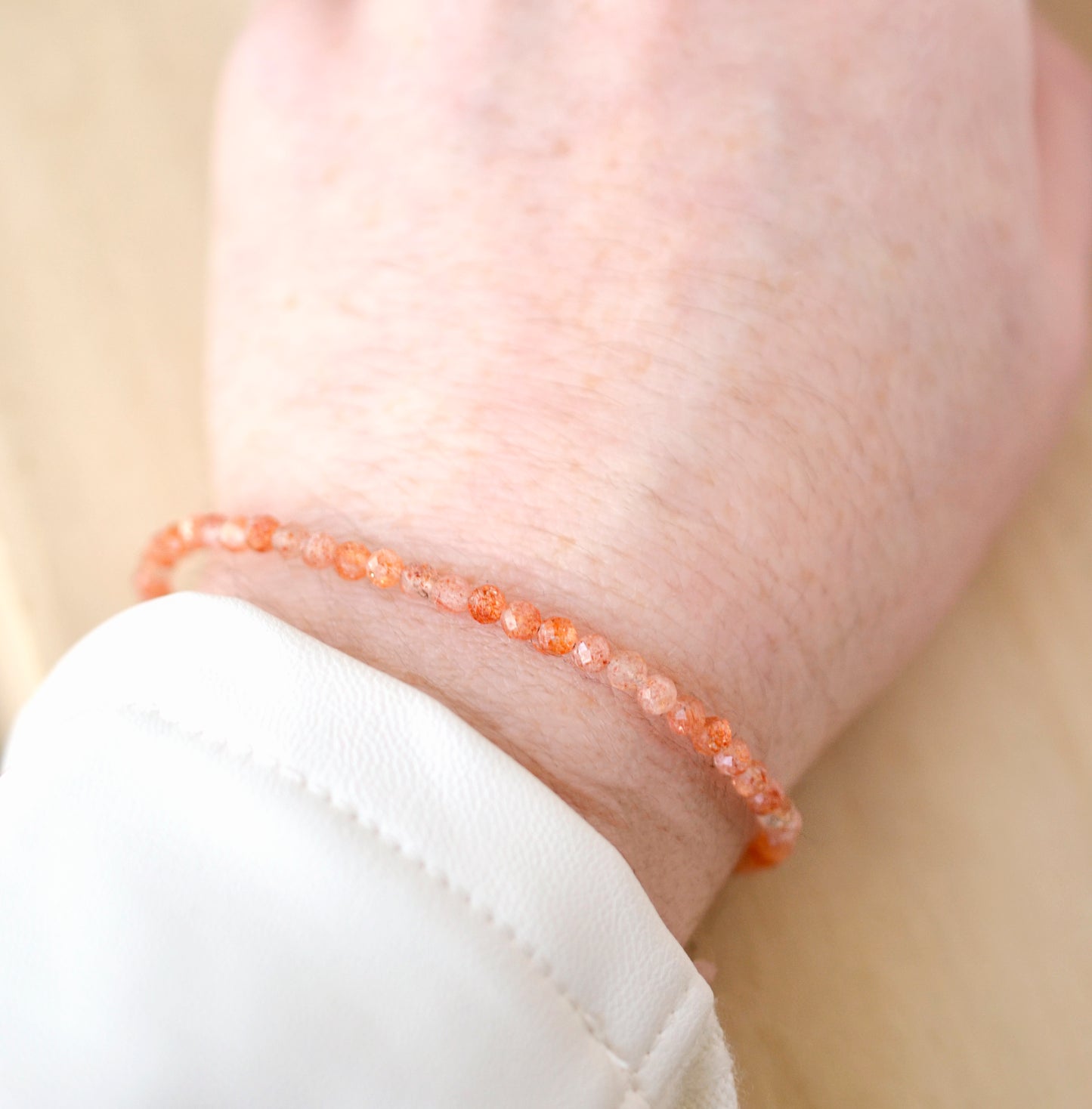 Dainty Sunstone beaded bracelet with orange to clear glittering gemstones. Clasp is sterling silver or gold filled.