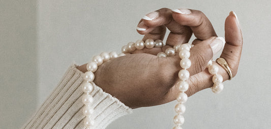 All About Pearls - Modeled image of single white pearl on gold chain.