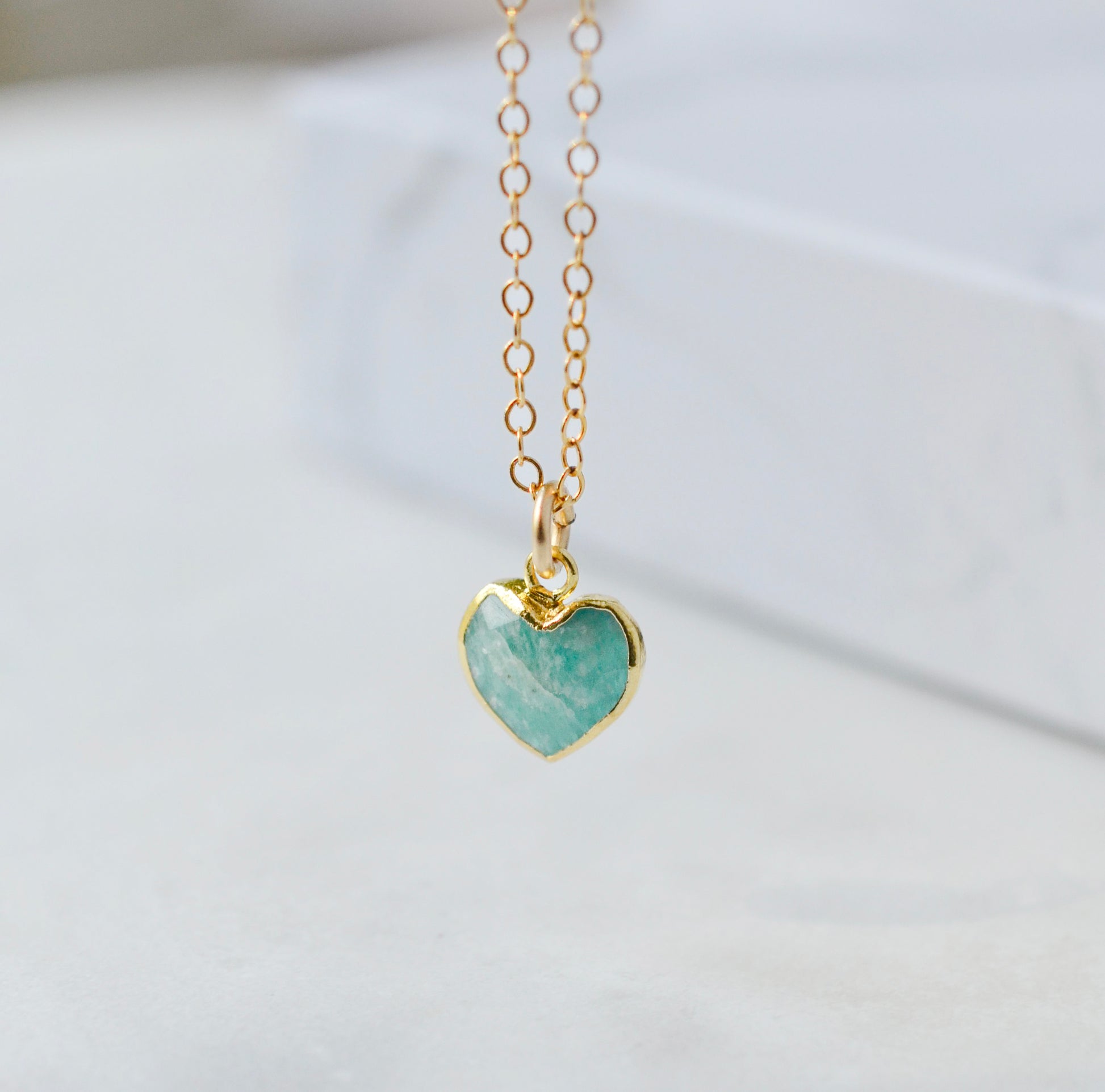 Natural blue green Amazonite gemstone pendant set on a 14k gold filled chain. The stone is a faceted heart shape and bezeled in 22k gold electroplate.