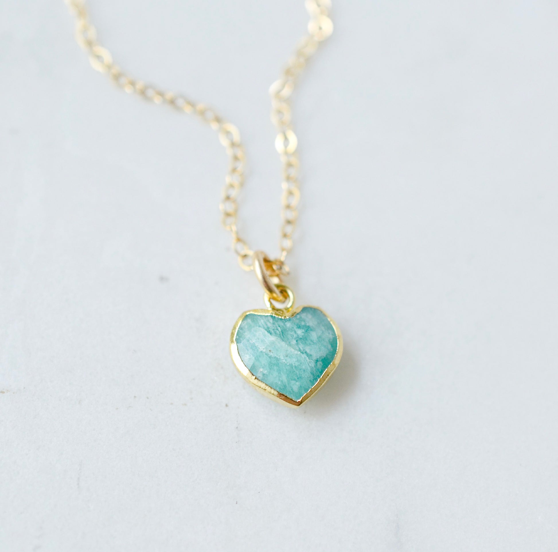 Natural blue green Amazonite gemstone pendant set on a 14k gold filled chain. The stone is a faceted heart shape and bezeled in 22k gold electroplate.