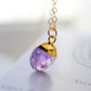 Close up of a real purple amethyst dainty stone pendant in gold. The necklace is handmade in new england by Gemnia Jewelry.
