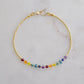 A beaded rainbow bracelet with natural crystal gemstones in the order of the chakras. This gold piece is handmade in Connecticut by Gemnia Jewelry.