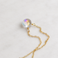 A gold chain necklace featuring a faceted, iridescent, clear mystic topaz teardrop pendant, on a 14k gold filled cable chain. The stone shifts rainbow colors with movement. Also available in sterling silver.