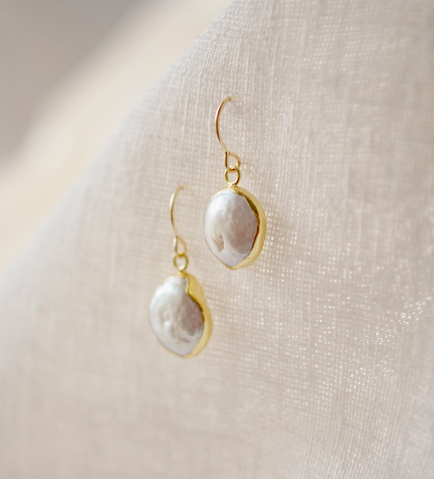 Natural white freshwater pearl dangle earring. The pearl is set in 22k gold electroplate and suspended from 14k gold filled earwires.