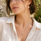 A woman modeling a natural rose quartz earrings and pendant in 14k gold filled. The gemstones are a pale, translucent pink and also available in sterling silver. 