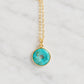 A closeup image of a circular donut pendant in turquoise. The stone is smooth polished and suspended from a dainty, minimalist 14k gold filled cable chain. Also available in sterling silver. Handmade by Gemnia in New England.