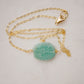 Aqua blue amazonite slice gemstone set onto a 14k gold filled chain. The stone is semi oval in shape, but irregular. It's smooth polished, but with raw edges. Shown with non-adjustable length clasp.