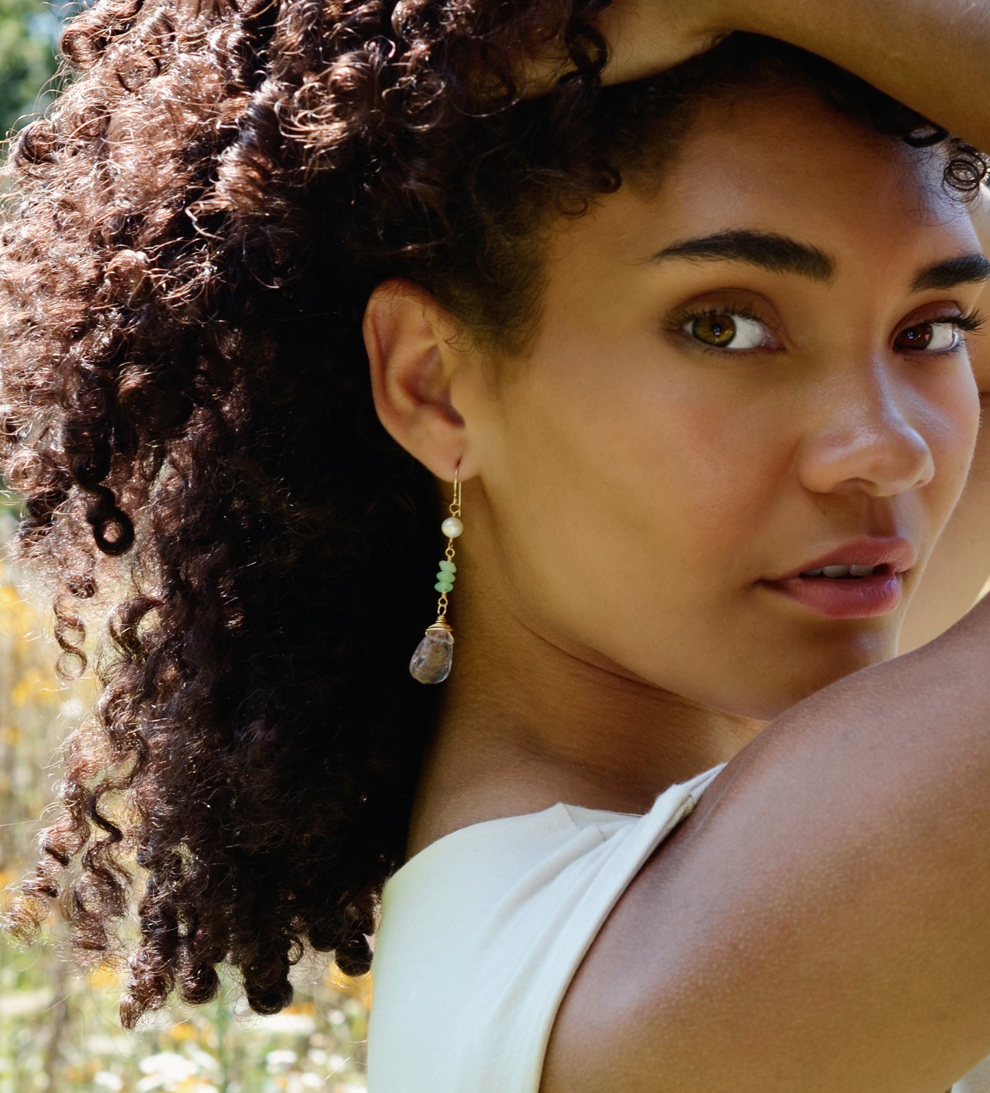 Long raw purple amethyst, green Chrysoprase, and white freshwater Pearl dangle earrings modeled in gold.