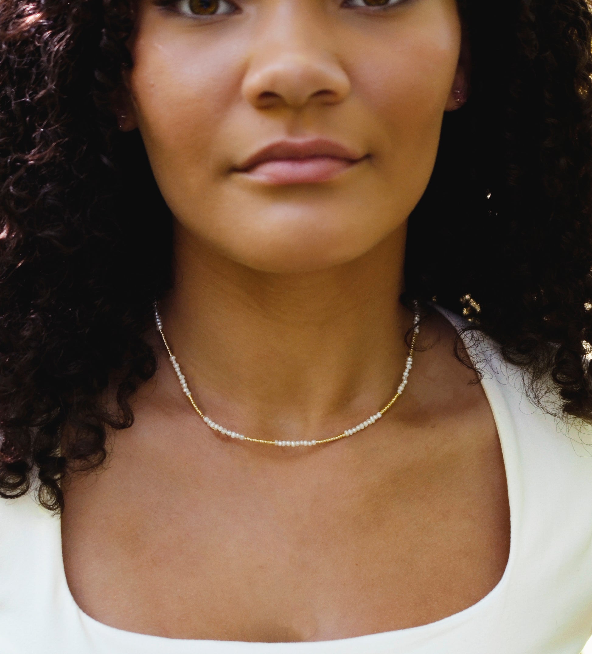 Beaded white freshwater pearl necklace modeled in the 14-16 inch style.