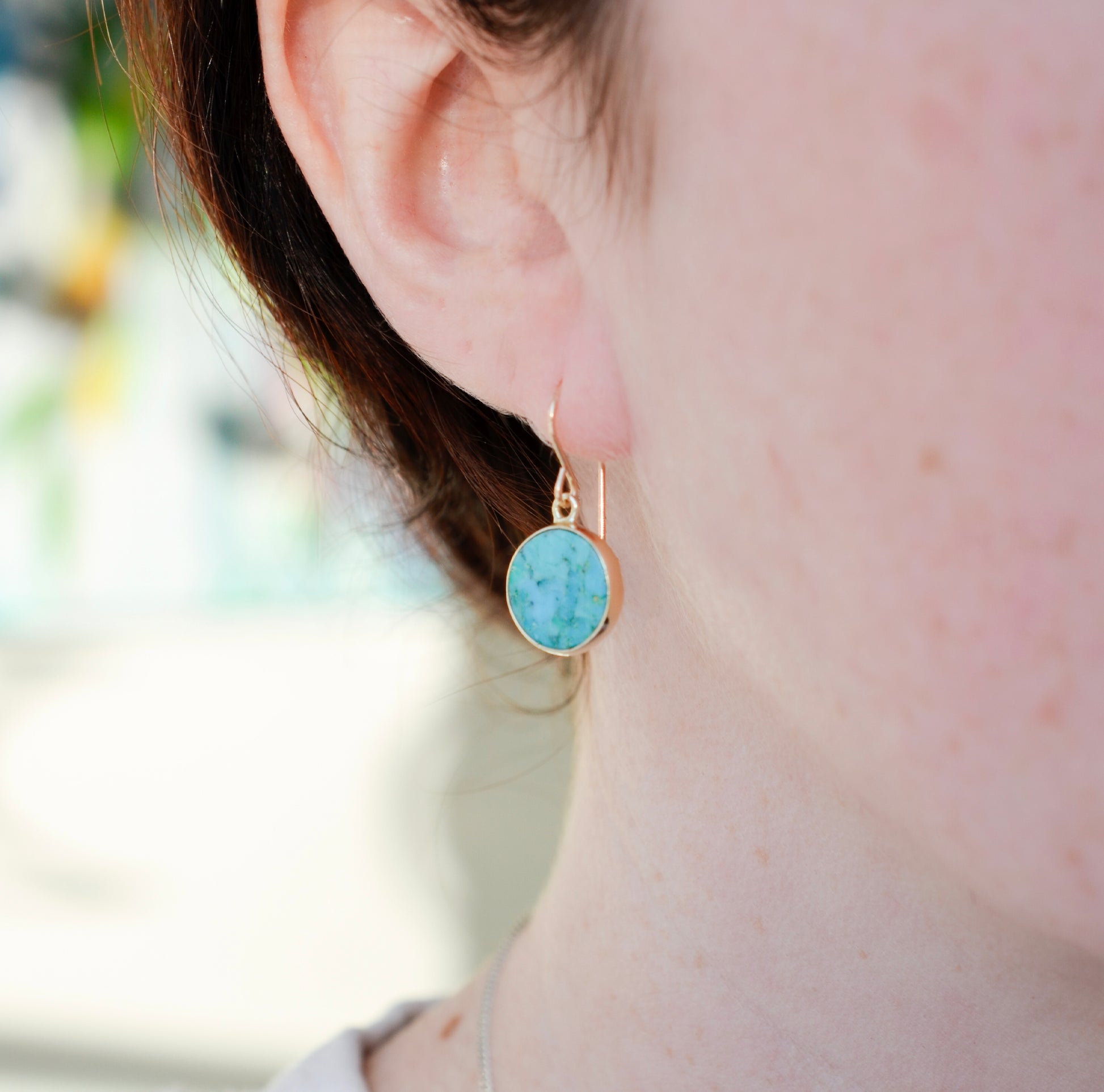 Modeled image of a woman wearing natural round coin shaped blue turquoise earring dangles in 14k gold filled.