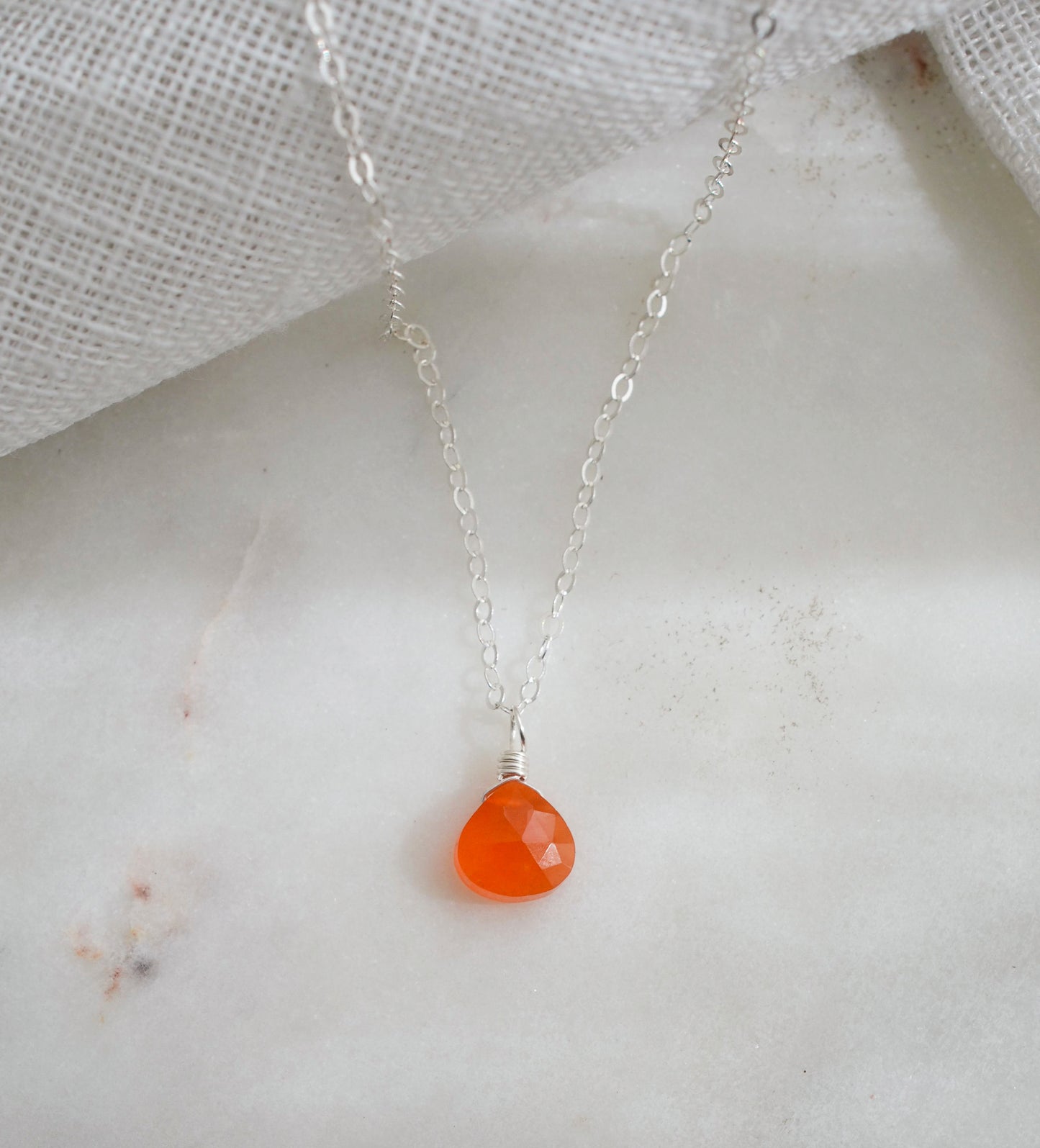 Genuine orange Carnelian crystal teardrop pendant on a sterling silver chain.