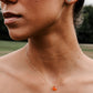 Handmade orange Carnelian Necklace. A single teardrop gemstone placed onto a sterling silver or gold filled chain. Modeled image.