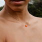 Handmade orange Carnelian Necklace. A single teardrop gemstone placed onto a sterling silver or gold filled chain. Modeled image.