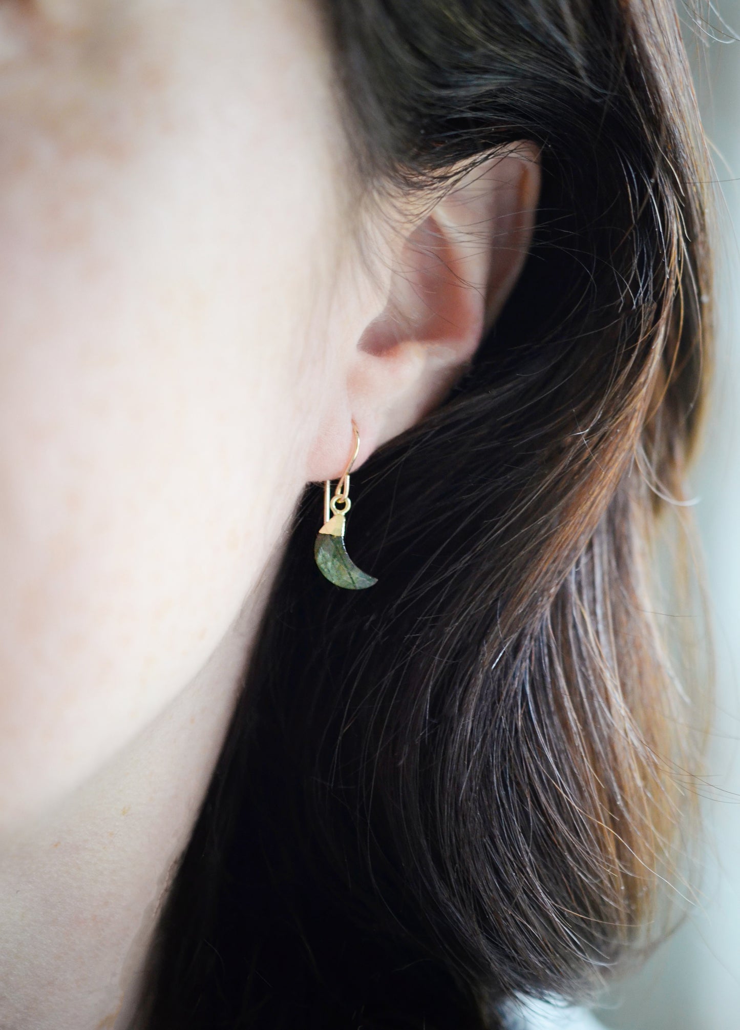 Labradorite Moon and Star earrings. One dangle is a faceted crescent moon, while the other is a star. The stones are naturally gray in color, but shift blue or green with movement. Available in gold or silver.