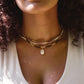 Single cowrie shell suspended from a 14k gold filled chain necklace. Modeled with other beaded crystal necklaces.