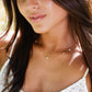 Close-up of a woman wearing a gold necklace with pearls. This necklace is handmade with natural white freshwater pearls set onto a 14k gold filled or sterling silver chain.