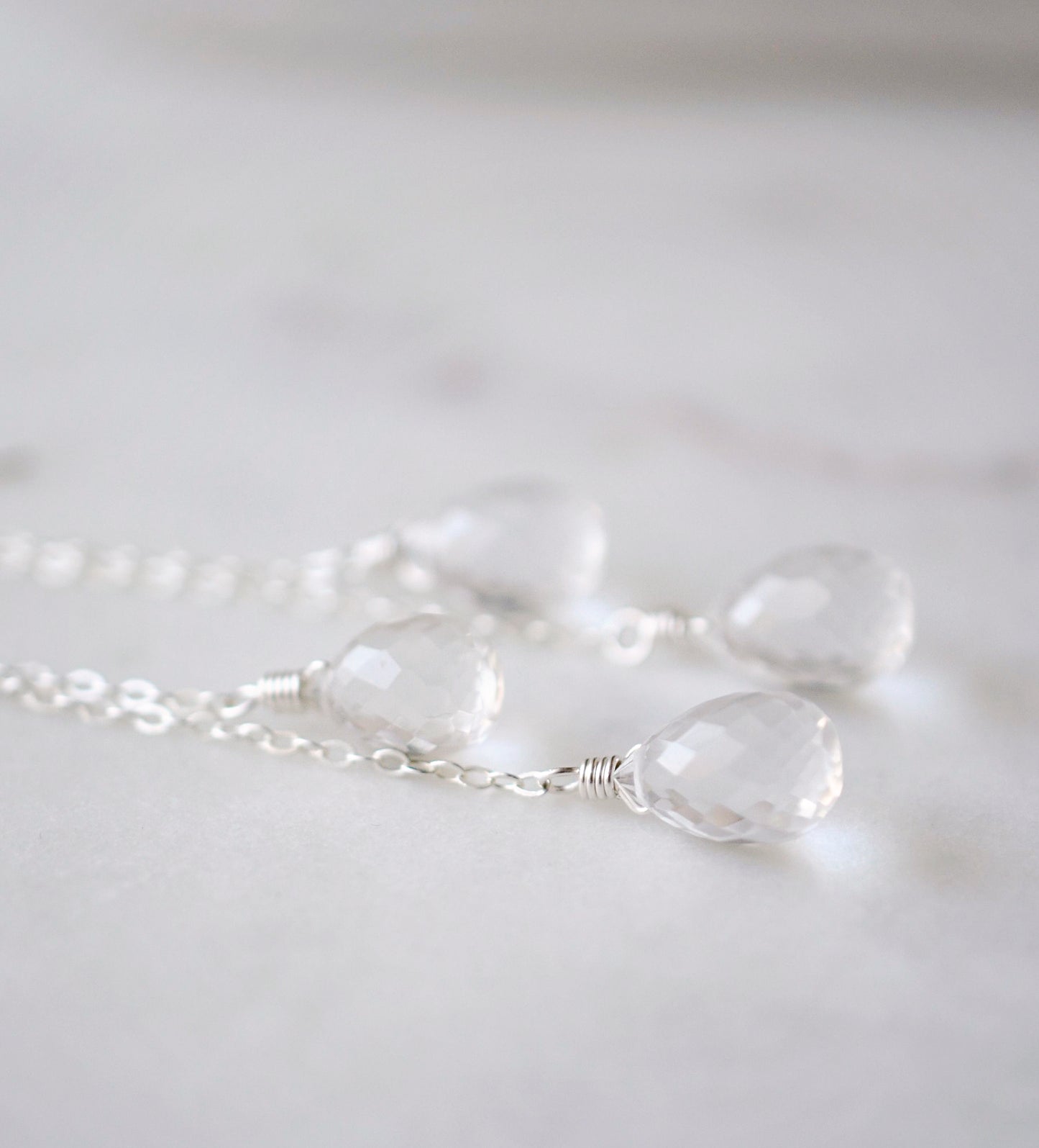Close up of clear crystal quartz teardrops. Earrings are shown in sterling silver.