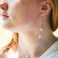 Long clear crystal quartz earrings with two teardrop dangles. Modeled in sterling silver.