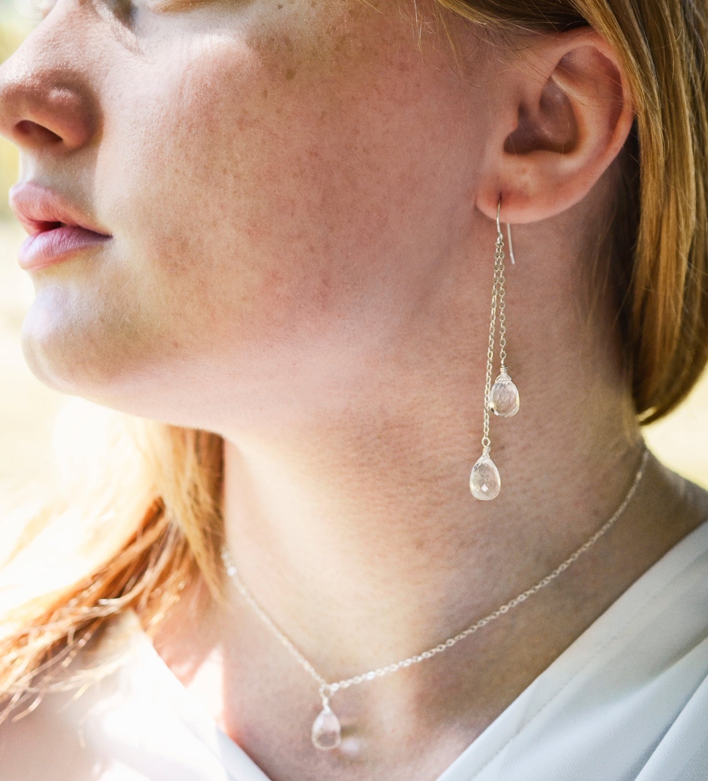 Long clear crystal quartz earrings with two teardrop dangles. Modeled in sterling silver.