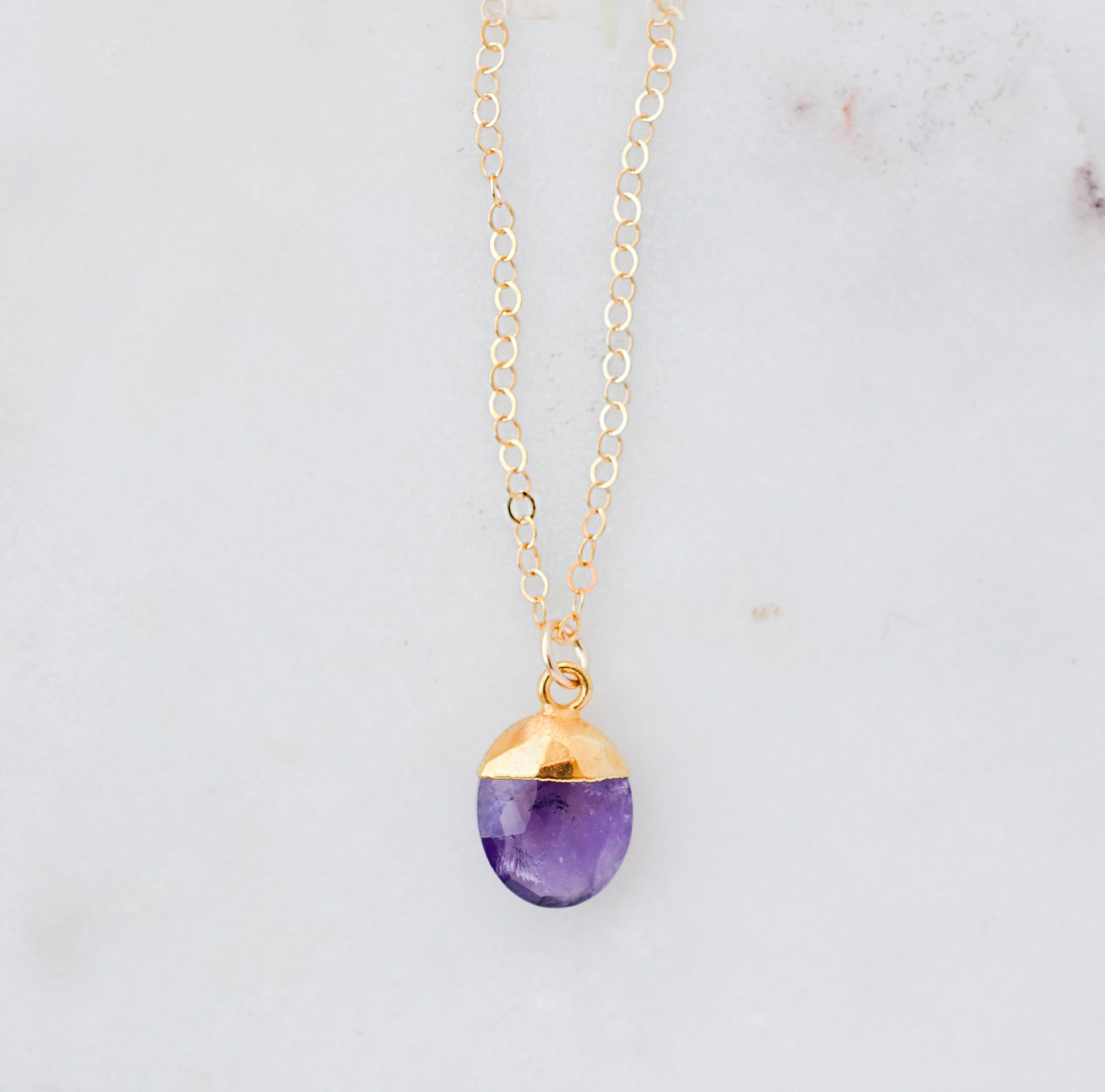 Necklace with a purple amethyst teardrop pendant and 14k gold filled dainty chain. Handmade gemstone jewelry in Connecticut by GEMNIA.