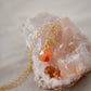Natural orange triangular shaped Carnelian gemstone set onto a gold chain. 