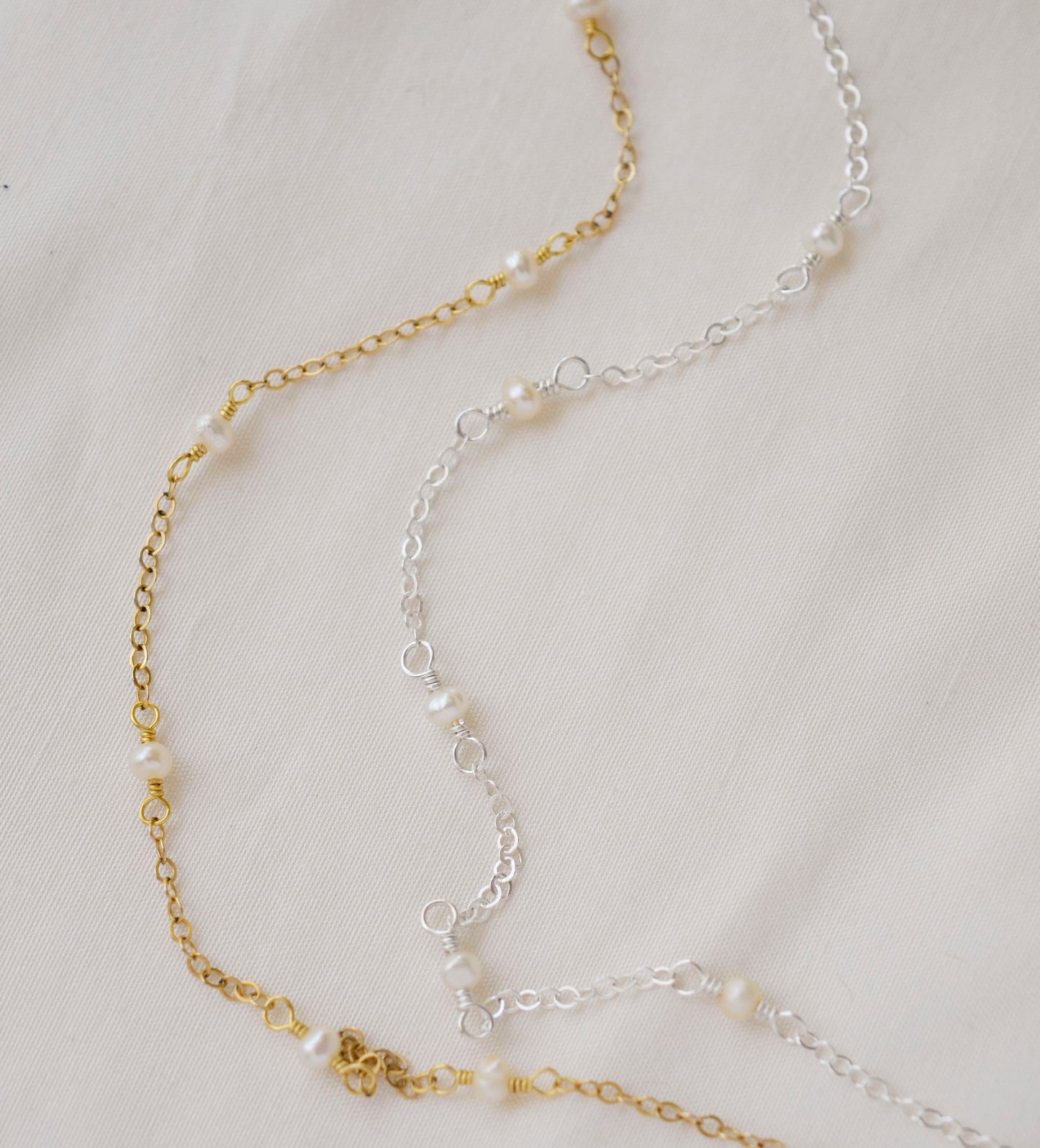 Gold and silver styles of the pearl chain necklace shown side by side. 