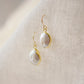 Side view. Natural white freshwater pearl dangle earring. The pearl is set in 22k gold electroplate and suspended from 14k gold filled earwires.