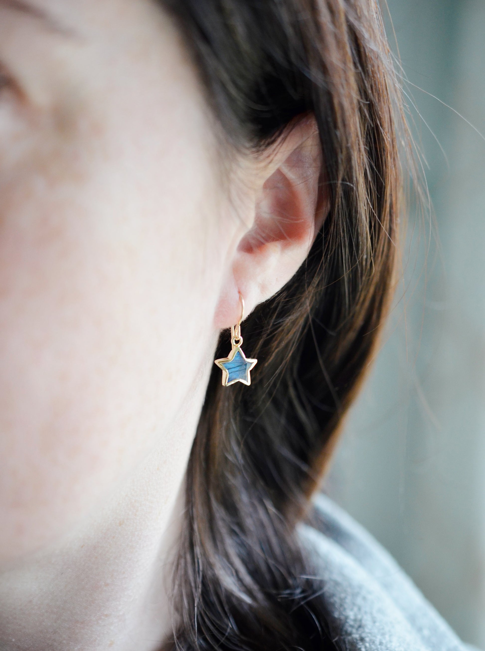 Labradorite Moon and Star earrings. One dangle is a faceted crescent moon, while the other is a star. The stones are naturally gray in color, but shift blue or green with movement. Available in gold or silver.