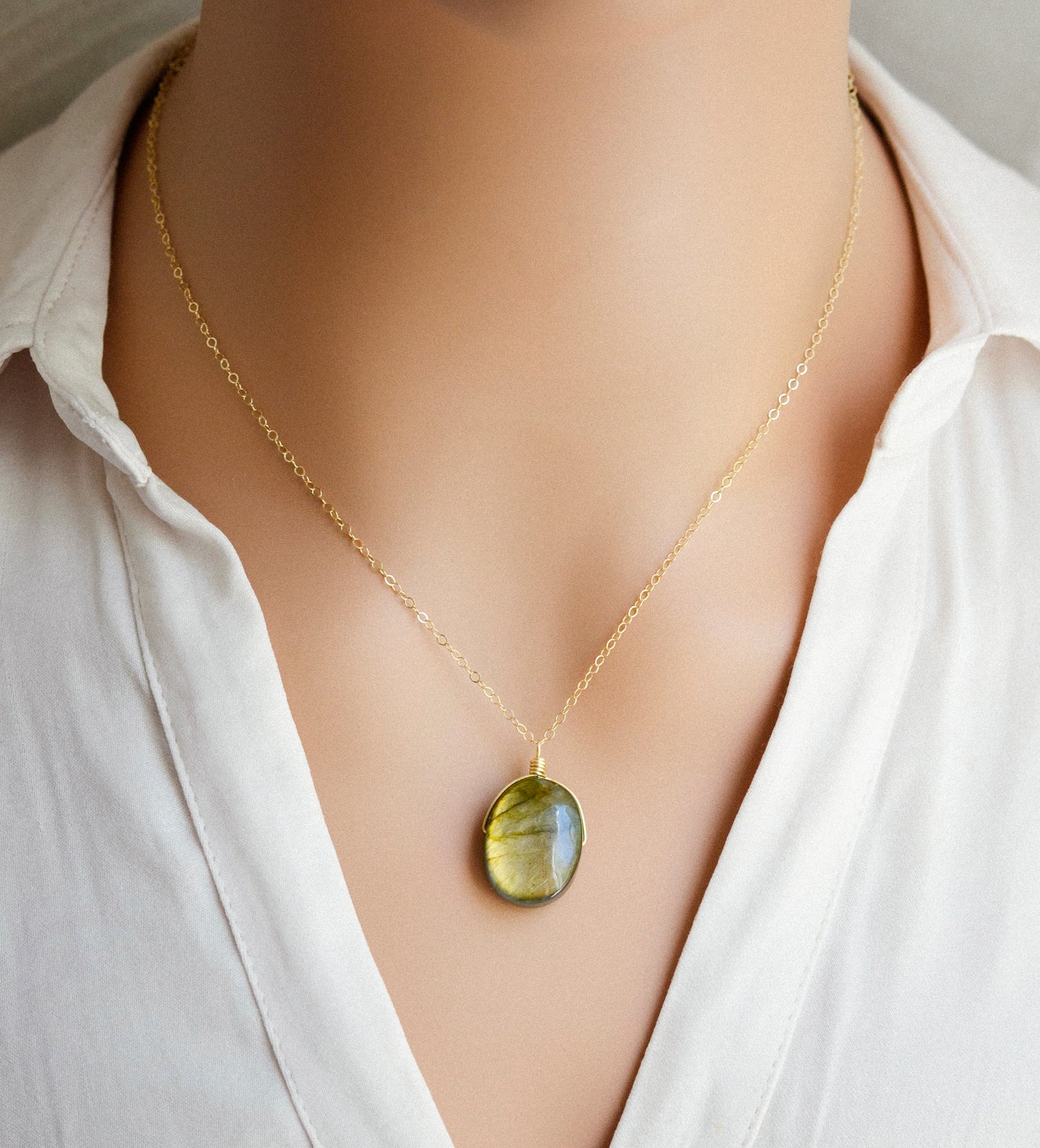 Labradorite oval pendant with yellow-green flash. The chain in 14k gold filled. Modeled image.