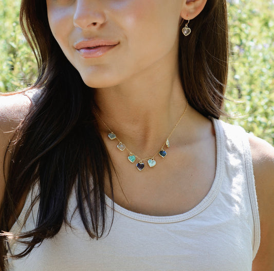 Modeled image: Handmade dainty heart necklace with heart-shaped gemstones on a 14k gold filed chain. Stones include: Aquamarine, Rose Quartz, Amazonite, Larimar, Labradorite, Amethyst, and Rainbow Moonstone