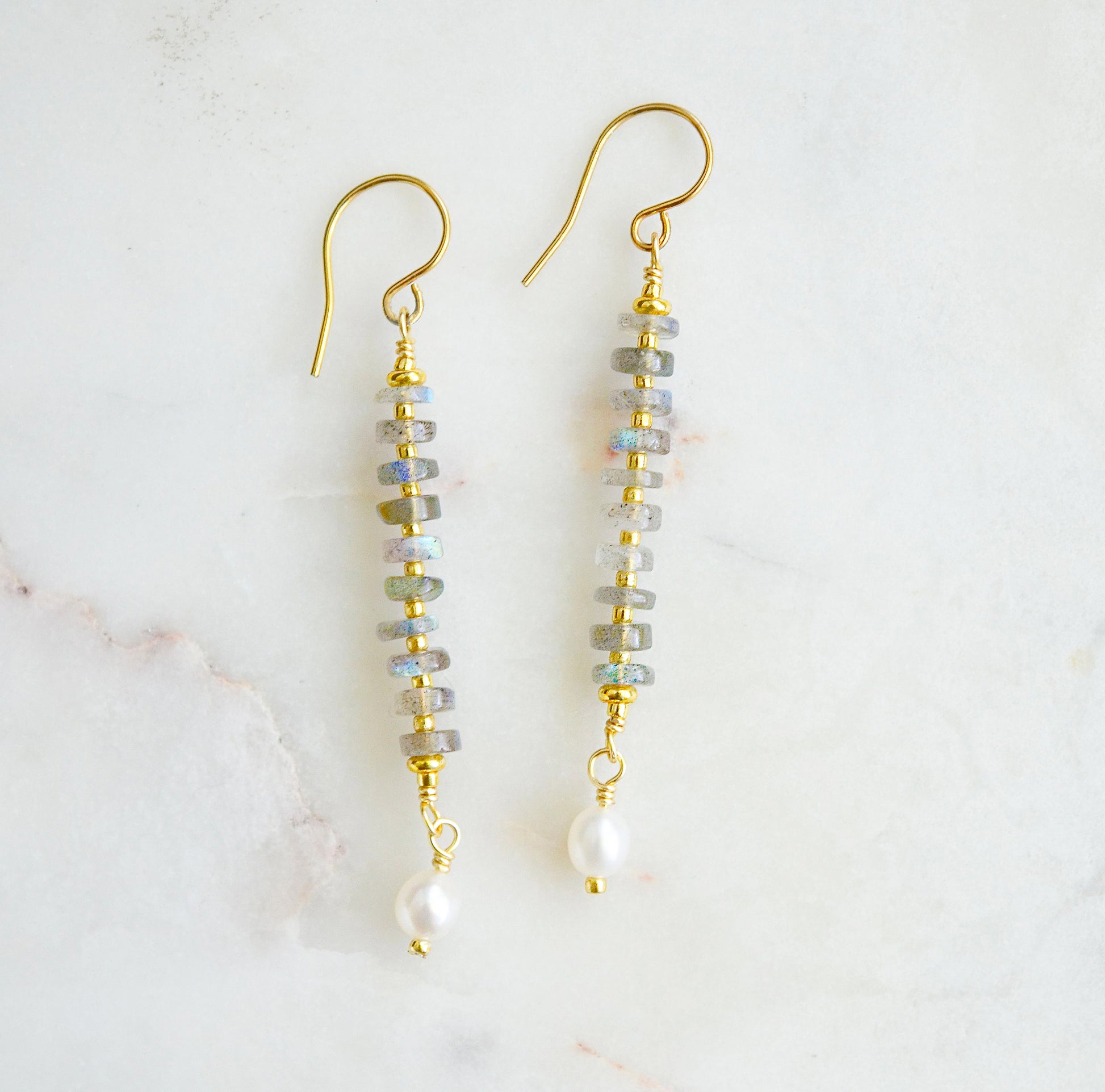 Handmade beaded dangle earrings with labradorite and white freshwater pearls. These artisan earrings are a long bar style with dainty pearls on the bottom. The gemstones flash blue and green.