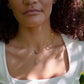 A dainty, gold, celestial style Labradorite star and moon necklace set layered on a model. This everyday jewelry is perfect for layering and stacking.