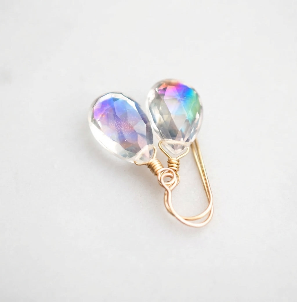 A pair of faceted mystic topaz teardrop dangle earrings in 14k gold filled. The gemstones are clear, but shift rainbow colors with movement. All jewelry is handmade by Gemnia in Connecticut. 