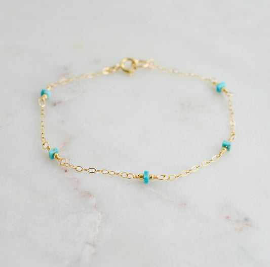A turquoise and gold filled bracelet with a chain-link design, featuring a gold filled band and turquoise stones. Handmade in Connecticut by Gemnia Jewelry.