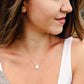 Single white oval shaped freshwater pearl suspended from a sterling silver or 14k gold filled cable chain. Modeled image.