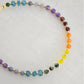 Beaded gemstone bracelet in rainbow colors. Handmade with natural gemstones including: yellow agate, orange carnelian, wine-red garnet, amethyst, tanzanite, topaz, and green emerald. Shown with a gold clasp.