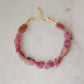 Raw pink tourmaline bracelet with tiny gold beads in-between each stone. The adjustable style is shown.