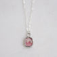 Natural pink Rhodochrosite sliced gemstone bezeled in sterling silver and set on a sterling chain.
