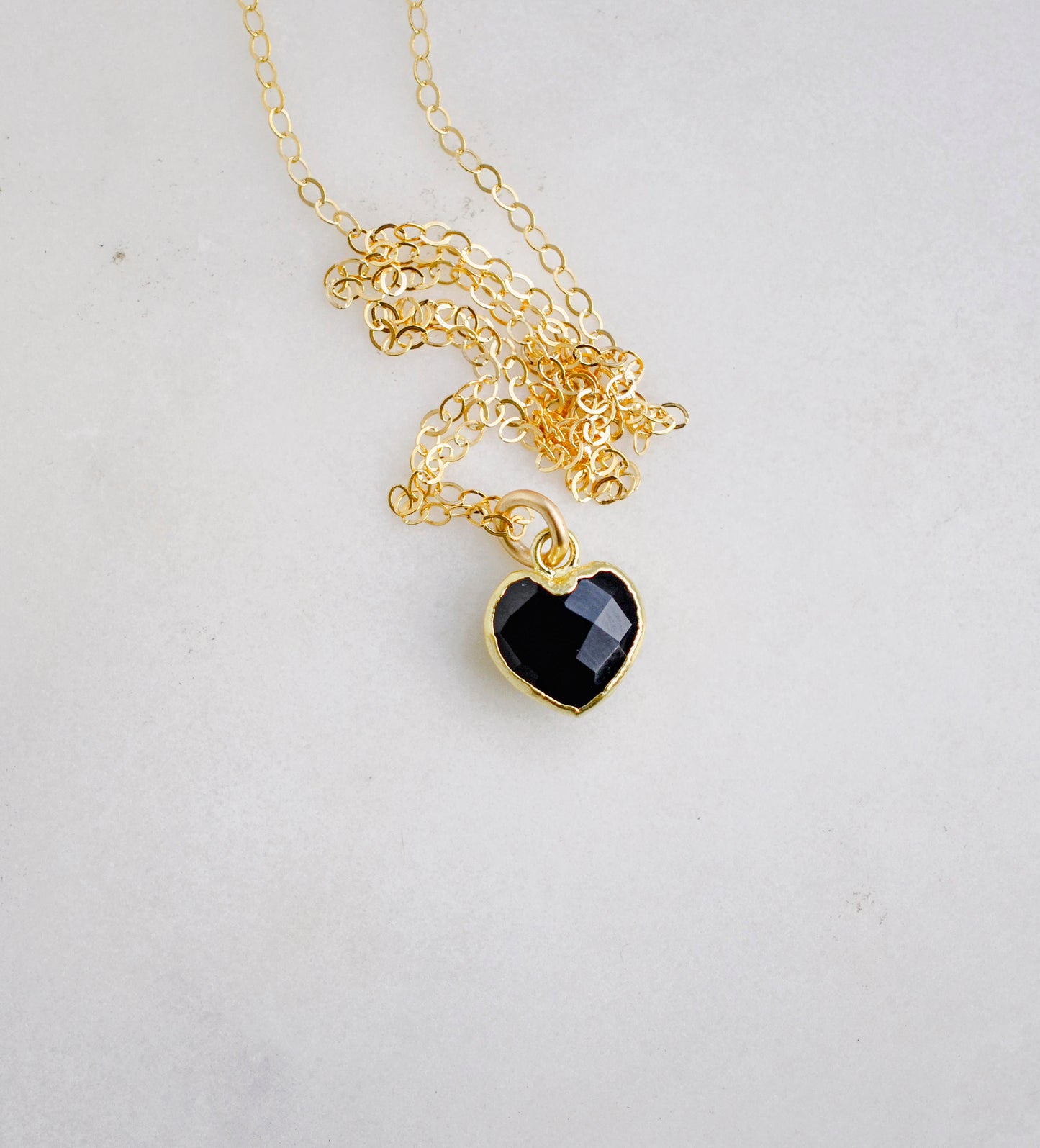 Black onyx heart pendant set on a 14k gold filled chain necklace.