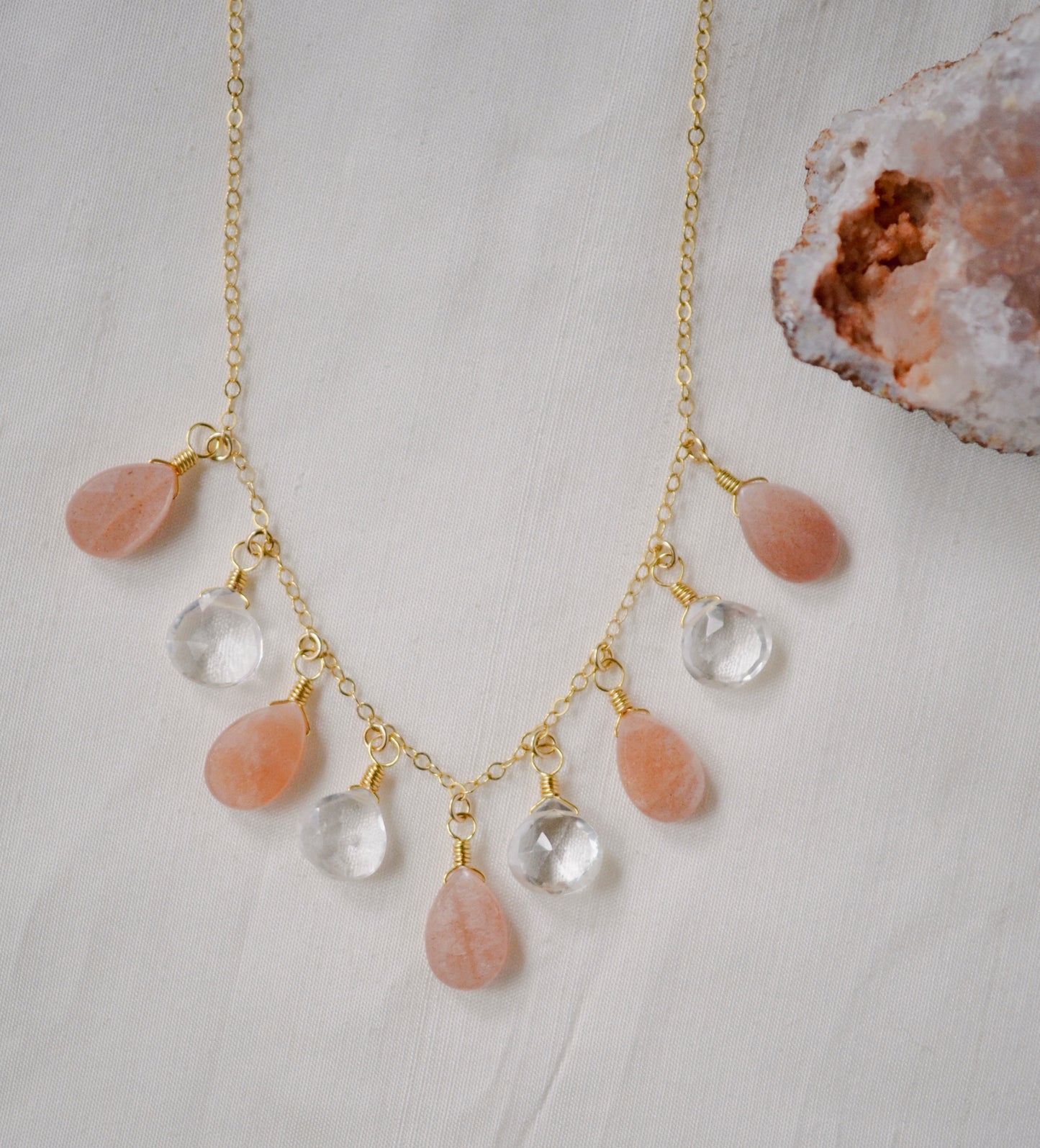 Handmade Necklace. Orange, peach Sunstone and clear Crystal Quartz teardrops dangle off a 14k gold filled chain. 