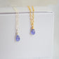 Close up of two real tanzanite pendants on sterling silver or 14k gold filled chains. The crystals are smooth polished and ultra dainty.